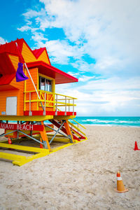 Lifeguard hut on beach against sky