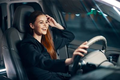 Portrait of young woman using mobile phone while sitting in car