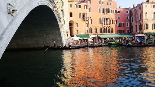 People on boat in canal along buildings