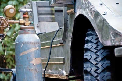 Close-up of gas cylinder by vehicle