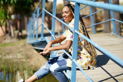 Low section of woman standing by railing