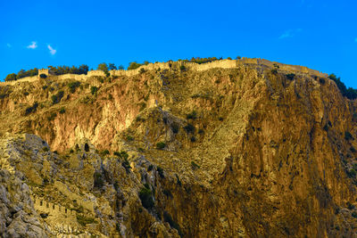 Old ruins on rocky mountains against sky