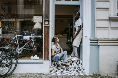 Full length of man sitting by building