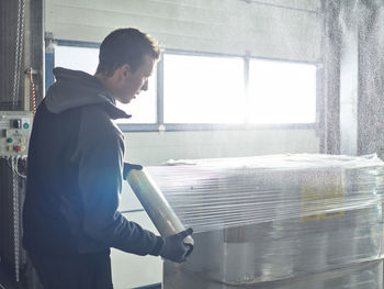 Worker closing freight with foil