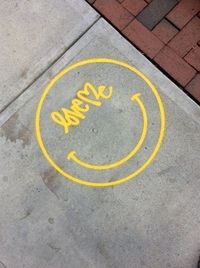 High angle view of yellow arrow symbol on road