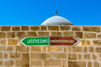 Low angle view of information sign against clear blue sky