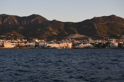 Scenic view of sea and mountains against clear sky