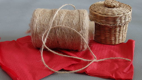 Close-up of spool by wicker basket on table