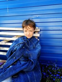 Portrait of young girl sitting on wooden bench