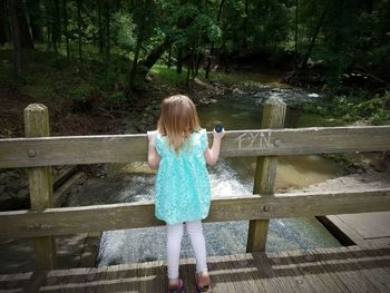 Rear view of girl standing on footbridge