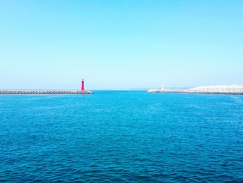 Sailboat sailing in sea against clear sky