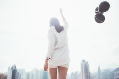 Rear view of woman holding black balloons