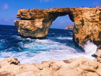 Scenic view of natural arch against blue sky