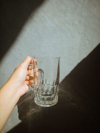 Close-up of hand holding glass bottle on table