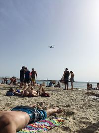 People at beach against clear sky