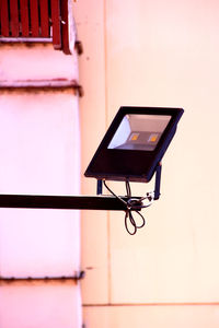 Low angle view of electric lamp against building