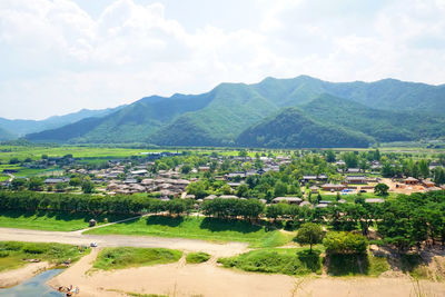 High angle view of field and mountains against sky