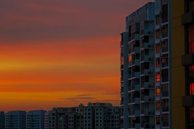 Buildings against dramatic sky during sunset