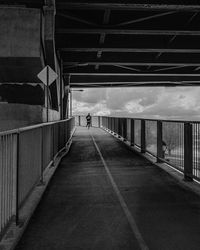 Rear view of man walking on bridge