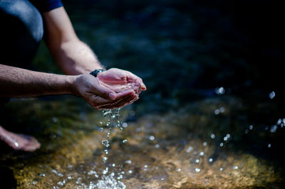 Close-up of hand holding wet water