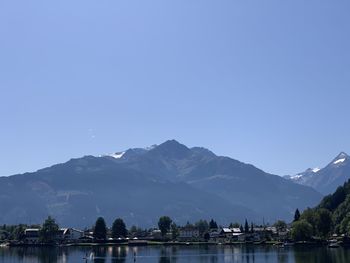 Lake by mountains against clear blue sky