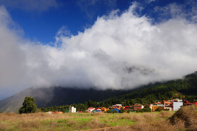 Scenic view of clouds over town at mountain