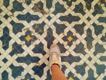 Low section of man standing on tiled floor