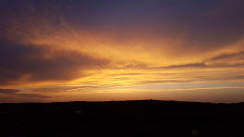 Scenic view of silhouette landscape against romantic sky at sunset