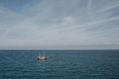 Sailboat sailing on sea against sky