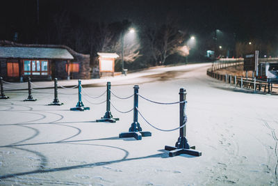 Illuminated street light on snow covered city at night