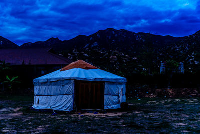 Tent on field against mountain at dusk