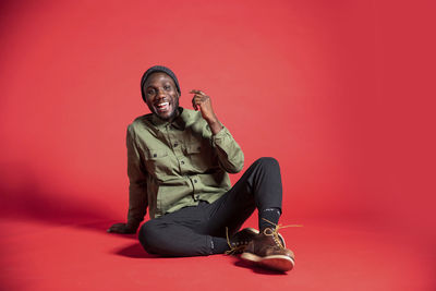 Young man looking away against red background