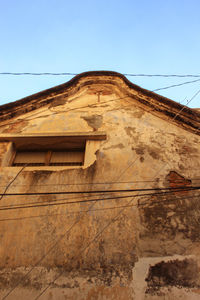 Low angle view of old building against clear blue sky