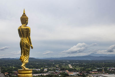 The buddha statue is located in the middle of the city.