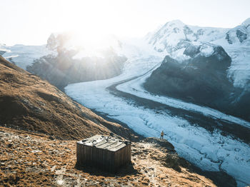 A hiker watching the sun come up over the gorner glacier near zermatt, switzerland.