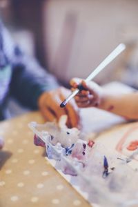 Cropped image of hand holding bouquet on table