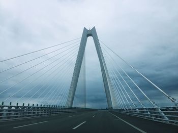 Low angle view of suspension bridge against sky