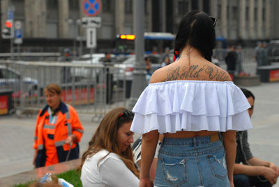 Rear view of people standing in city