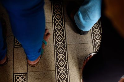 Low section of woman standing on tiled floor