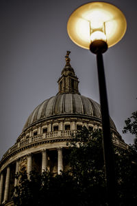 Low angle view of illuminated street light against building