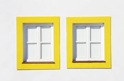 Closed yellow windows on wall