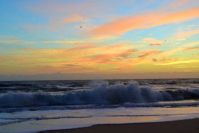 Waves splashing on rocks at sunset