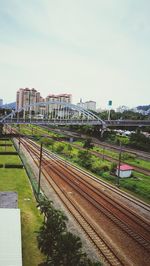 Railroad tracks in city against sky