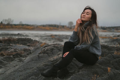 Young woman sitting on rock