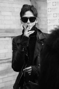 Portrait of young woman wearing sunglasses standing outdoors