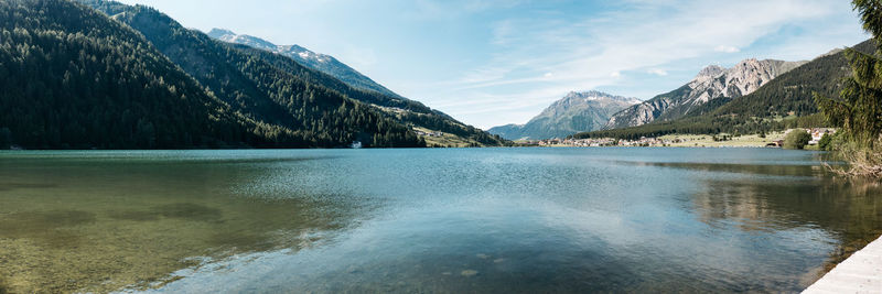 Scenic view of lake by mountains against sky