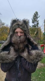 Portrait of young woman with fur hat in park