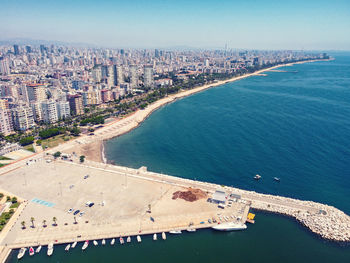 High angle view of city by sea against sky