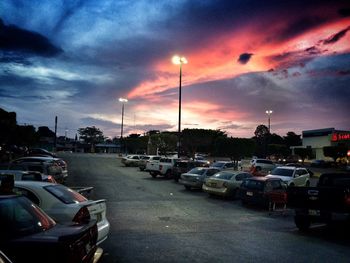 Cars on road against sky during sunset