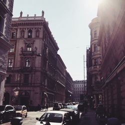 Traffic on road amidst buildings in city